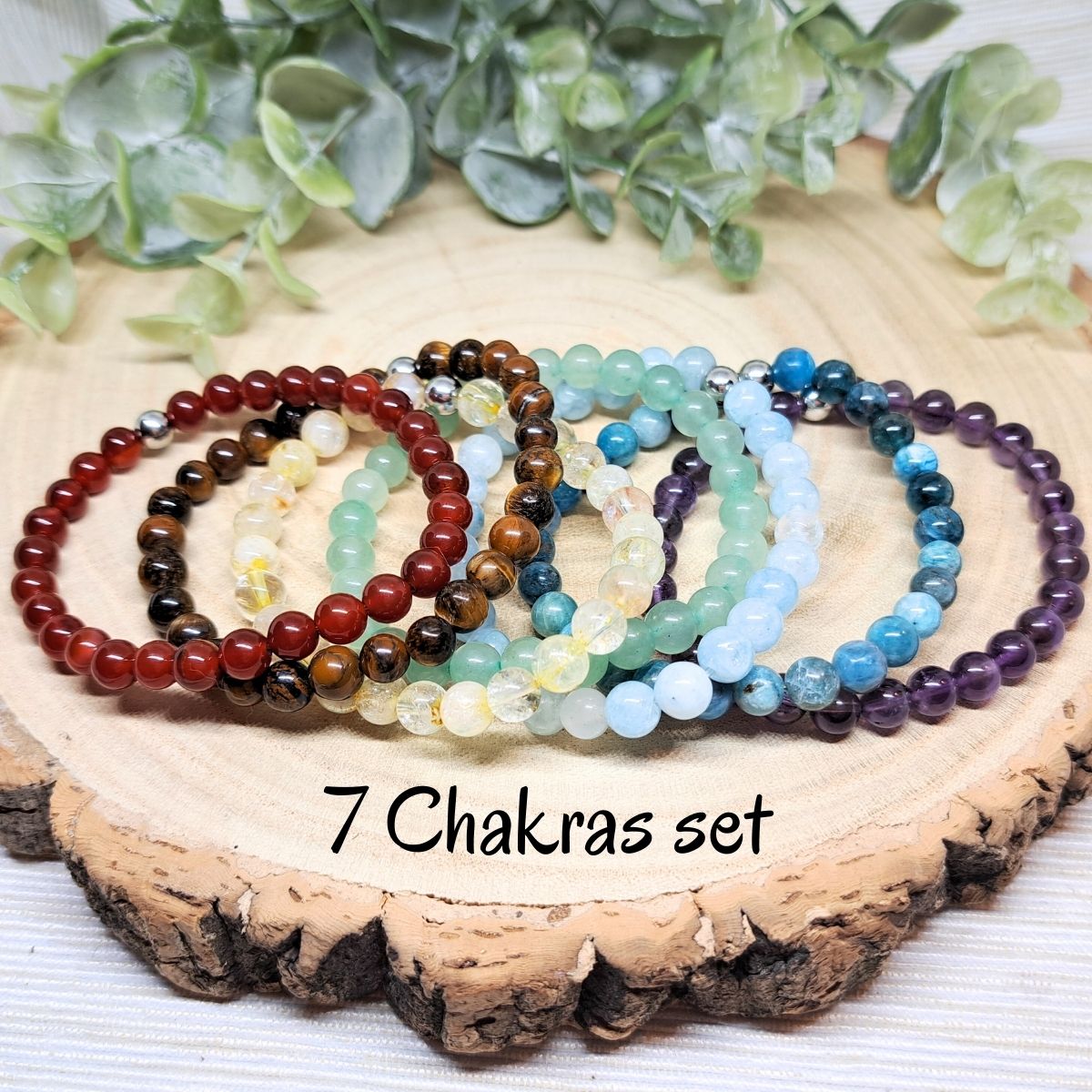 Different colors bead bracelets on a wood surface.