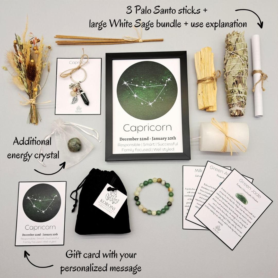 Products from a Capricorn gift box, placed outside the box on a surface. Print in frame, crystal bracelet, keychain, aroma materials and other products and explanations for some of them.