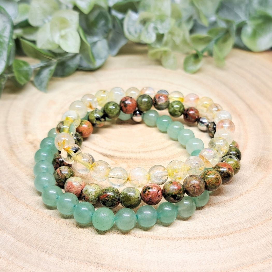 Green and yellow bead bracelets on a wood surface.