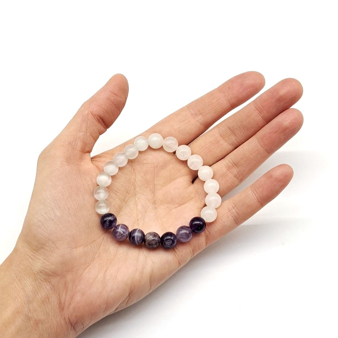 Healing gemstone bracelet held in hand.
