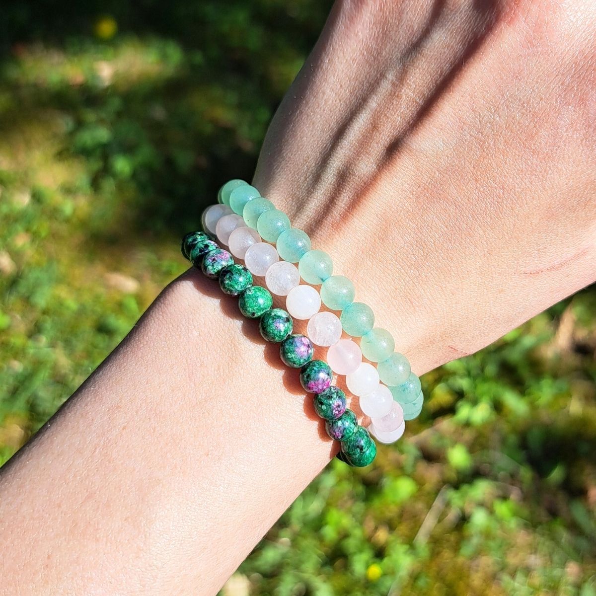 Three crystal bead bracelets on a wrist.