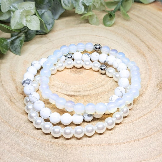 A set of 3 crystal blue and white bracelets on a wood surface.