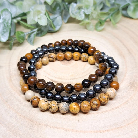 3 crystal bead bracelets on a wood surface.