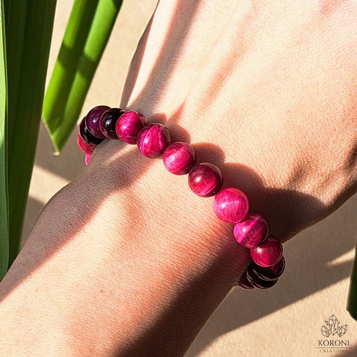 Pink Tiger Eye bracelet on a wrist.