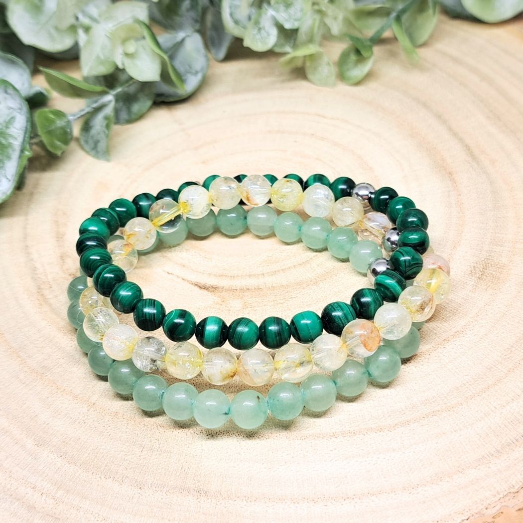 Green and yellow bead bracelets on a wood surface.