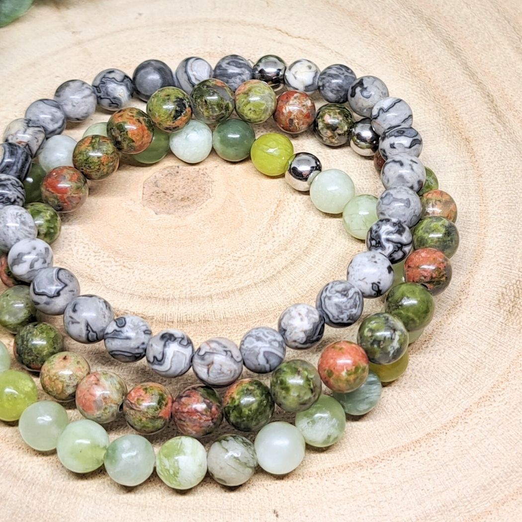 3 crystal bead bracelets on a wood surface.