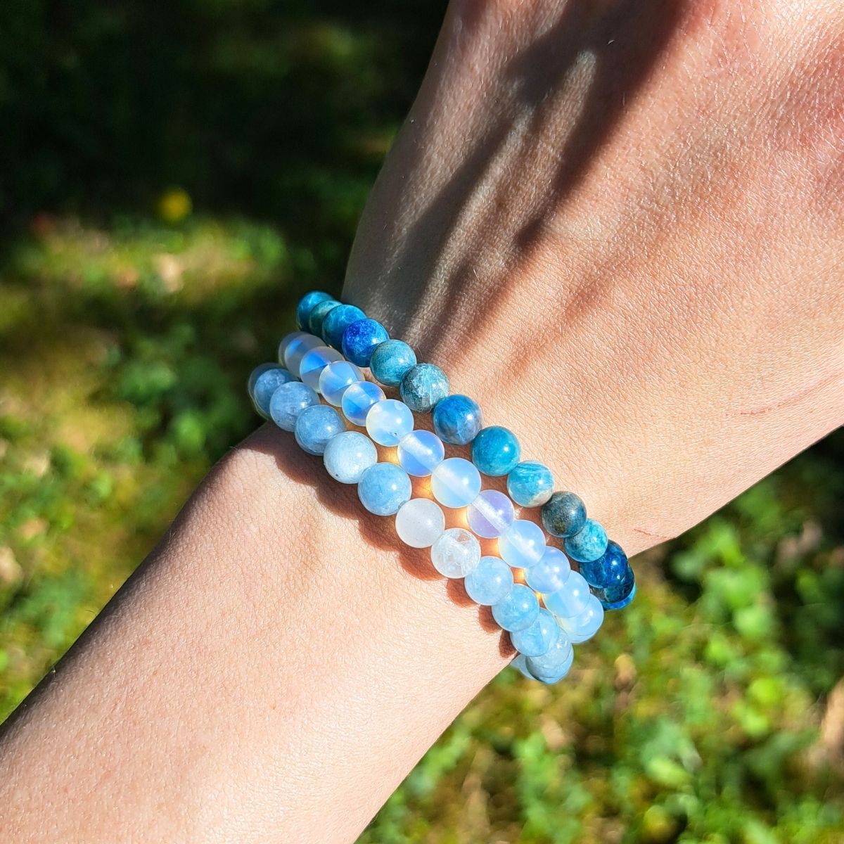 3 light blue bead bracelets on a women wrist.